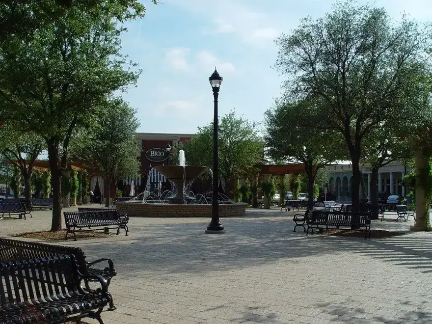 Southlake Town Square plaza with a fountain, canopy trees and benches